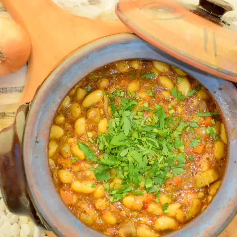 overhead view of baked beans in clay pot