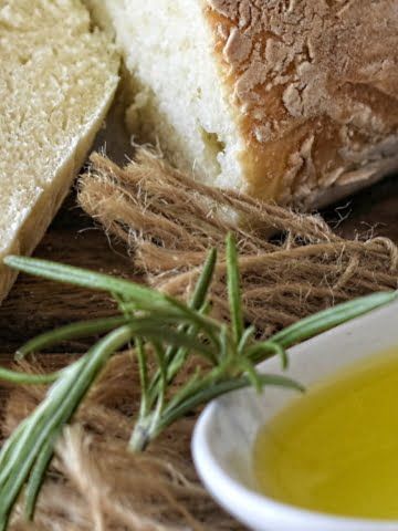 ¾ view of a spoon of olive oil and sliced white bread