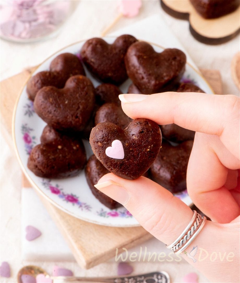 a hand is showing one of the healthy vegan brownie hearts to the camera