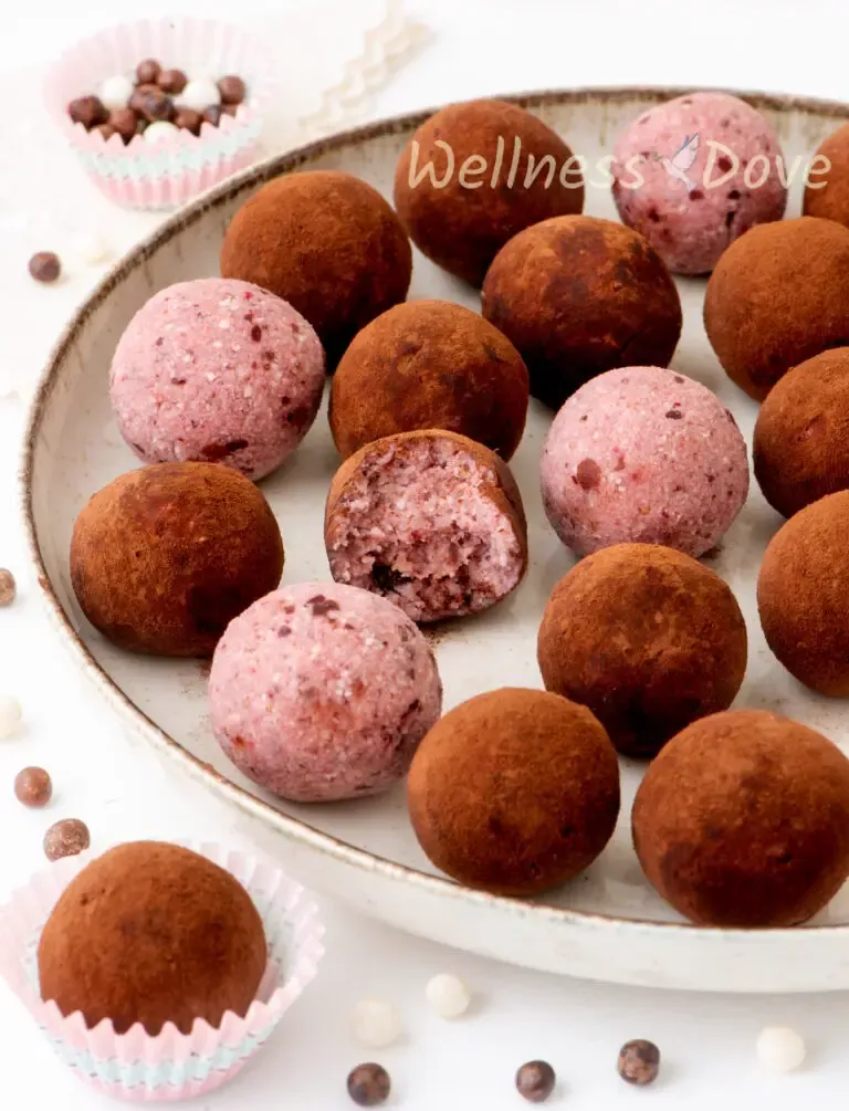 the Addicting no bake strawberry vegan truffles that are quick and easy to make. A delicious healthy treat made with only 5 simple wholesome ingredients. So easy, delectable, and rich.  in in a large plate, a 3/4 view