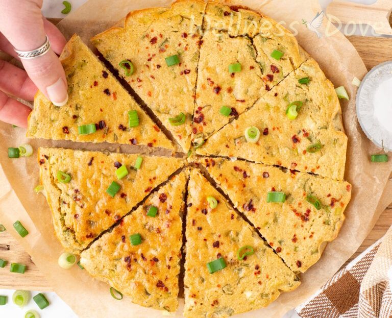 an overhead view of the easy gluten free chickpea flatbread while a hand is taking a piece