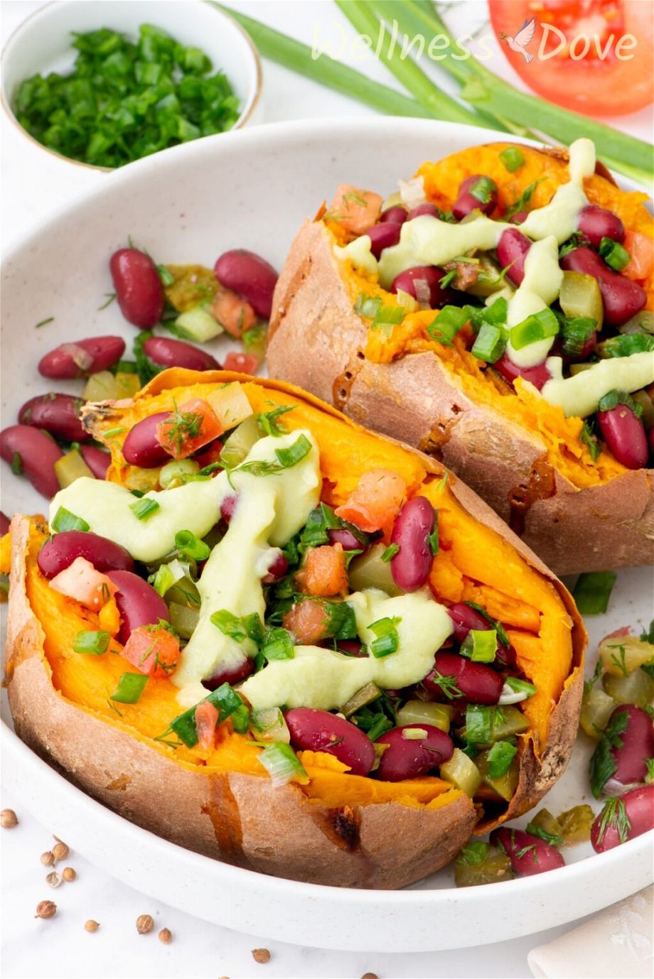 two of the bean stuffed vegan sweet potatoes in  a large bowl