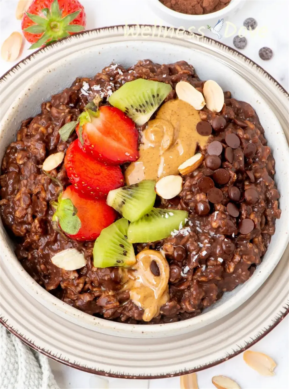an overhead view of the chocolate vegan oatmeal in a shallow bowl on top of a plate