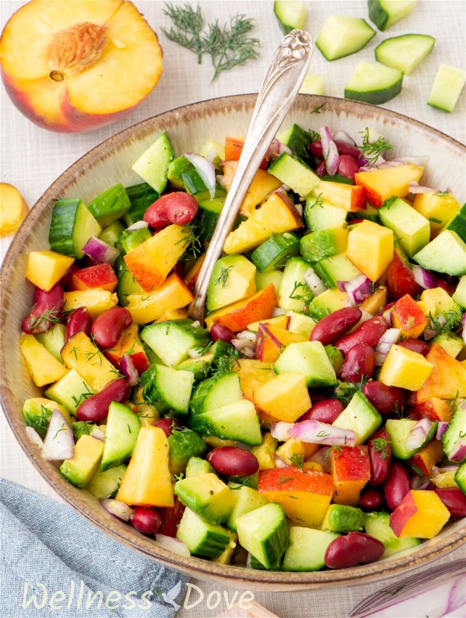 the vegan peach salad with beans in a beautiful brown -white bowl
