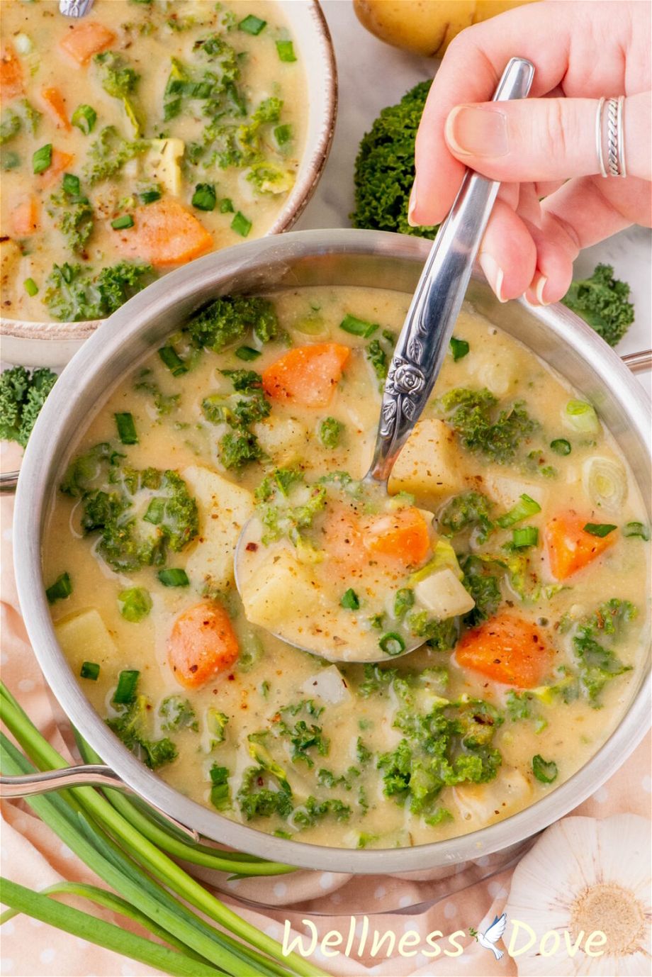 the Creamy Kale Potato Vegan Soup in a pot with a laddle inside