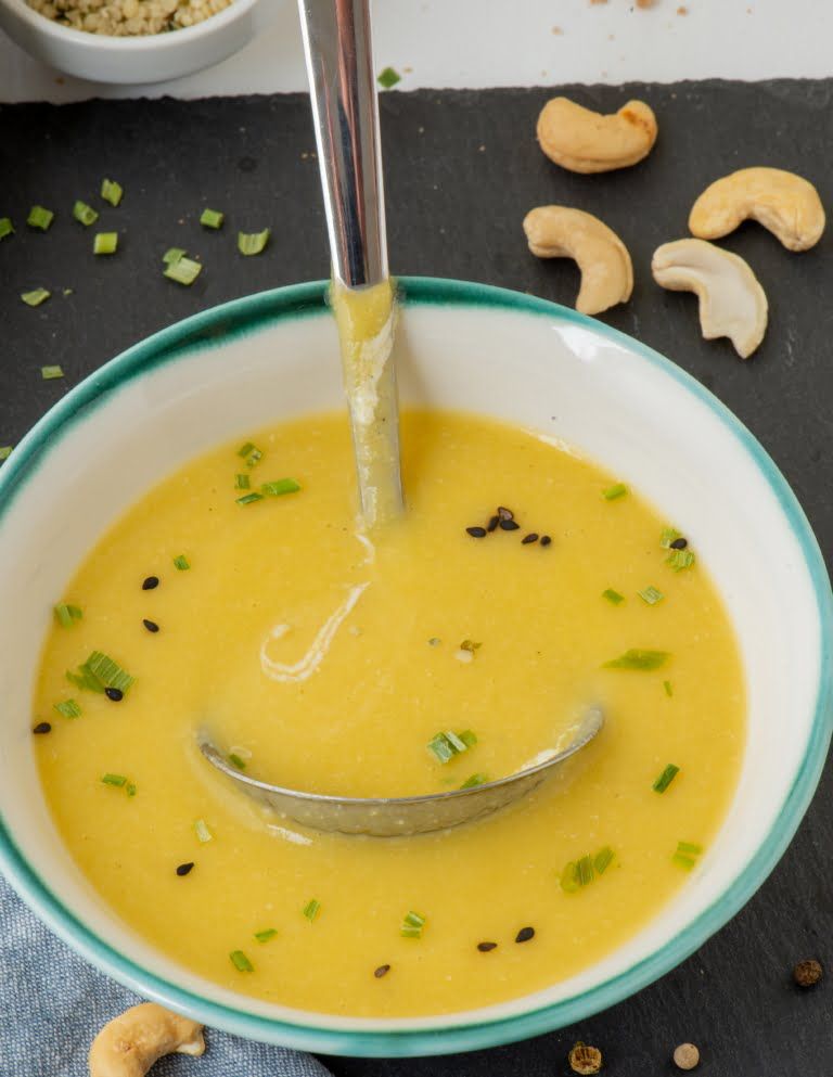 a plate with the zucchini vegan soup with a ladle inside