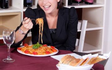 woman eating pasta in a restaurant