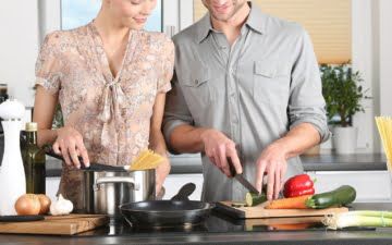 a young couple cooking in the kitchen