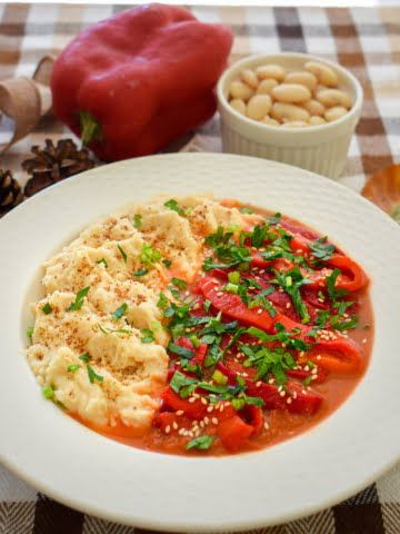 A plate full of roasted peppers in tomato sauce ¾ view