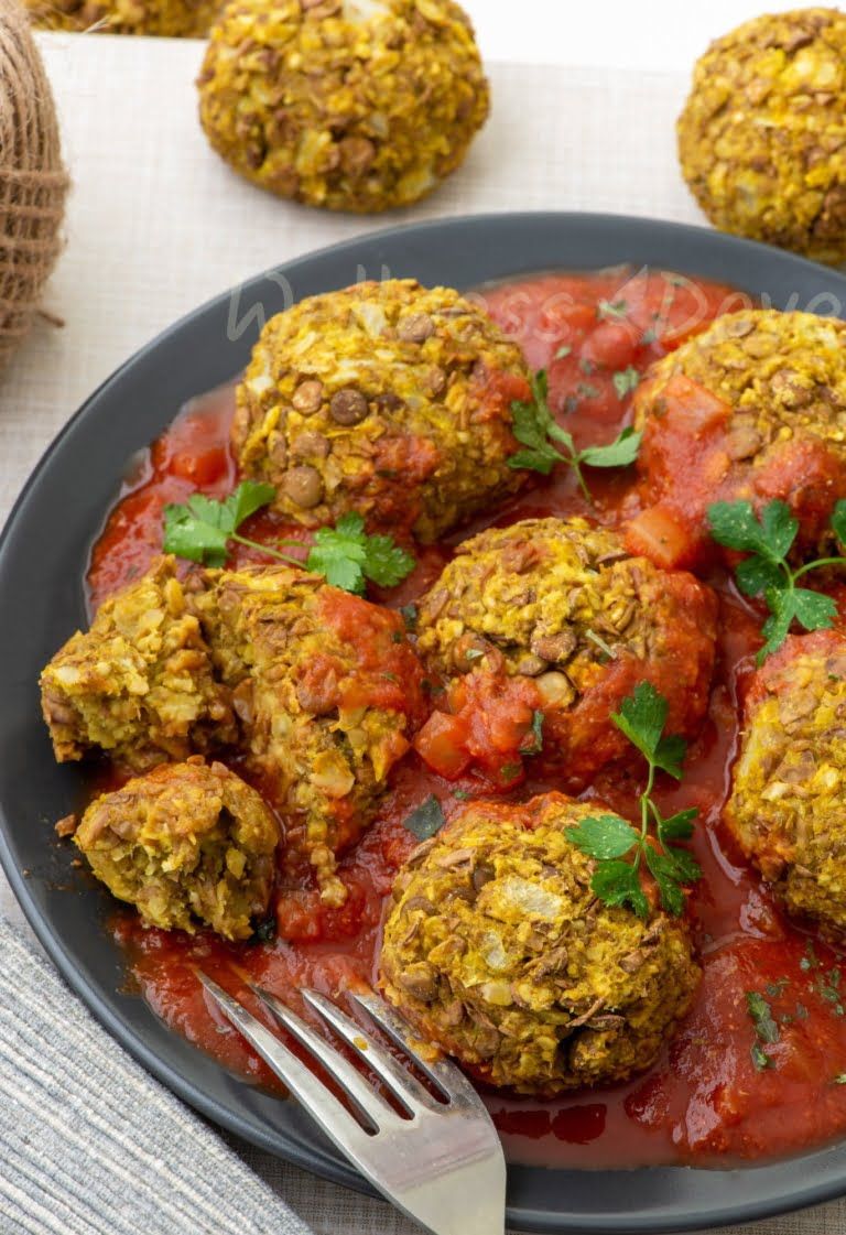 vegan meatballs in a plate, with a fork in front of the plate, 3/4 angle