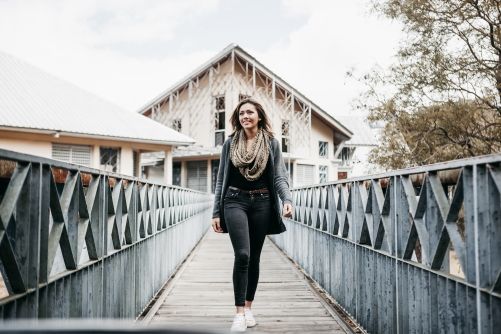 Smiling woman walking on a bridge