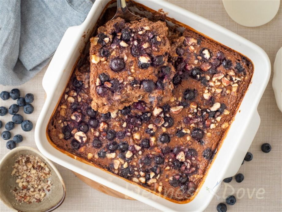 overhead view of a pot with ovenbaked vegan blueberries and a spatula taking a piece