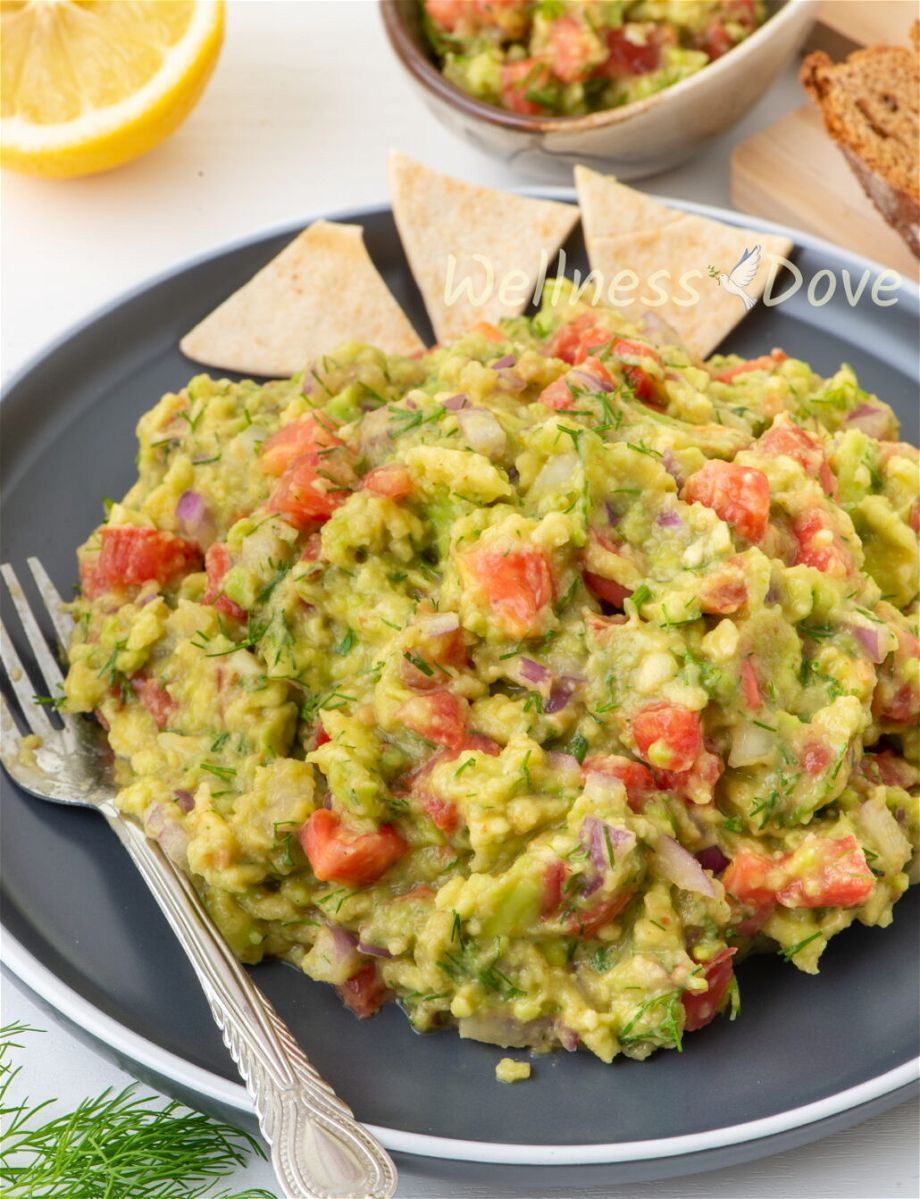 the vegan homemade guacamole in a black plate