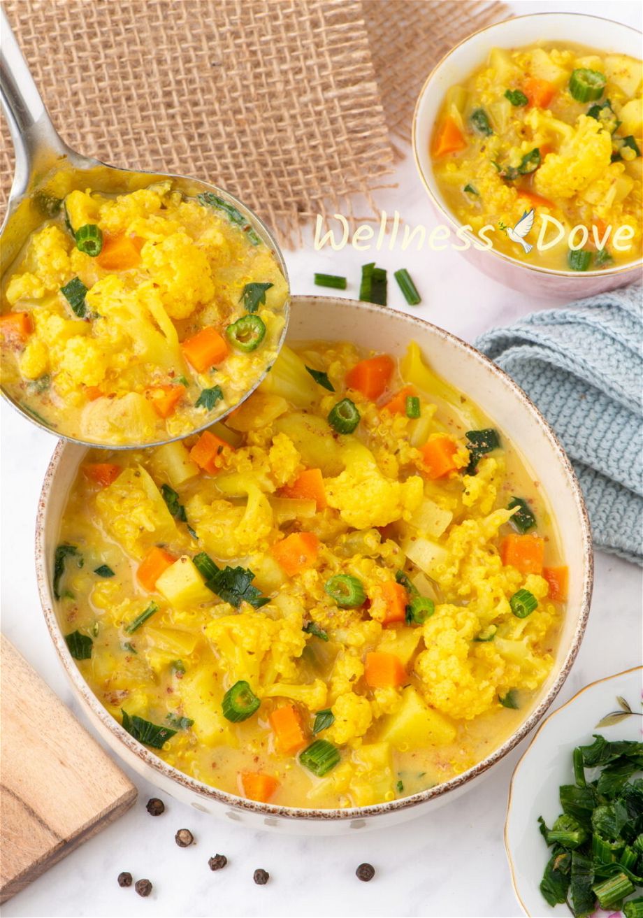 the Cauliflower Vegan Soup with Quinoa in a bowl and a ladle is taking some of it away