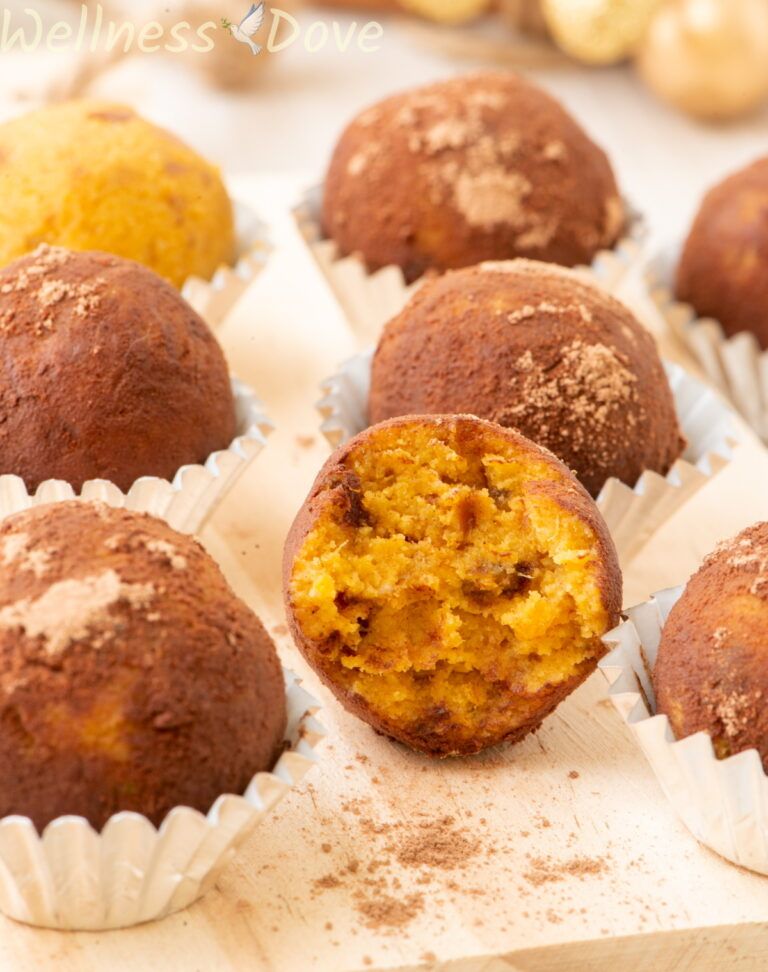 a close up image of the easy vegan pumpkin truffles, one truffle is half eaten