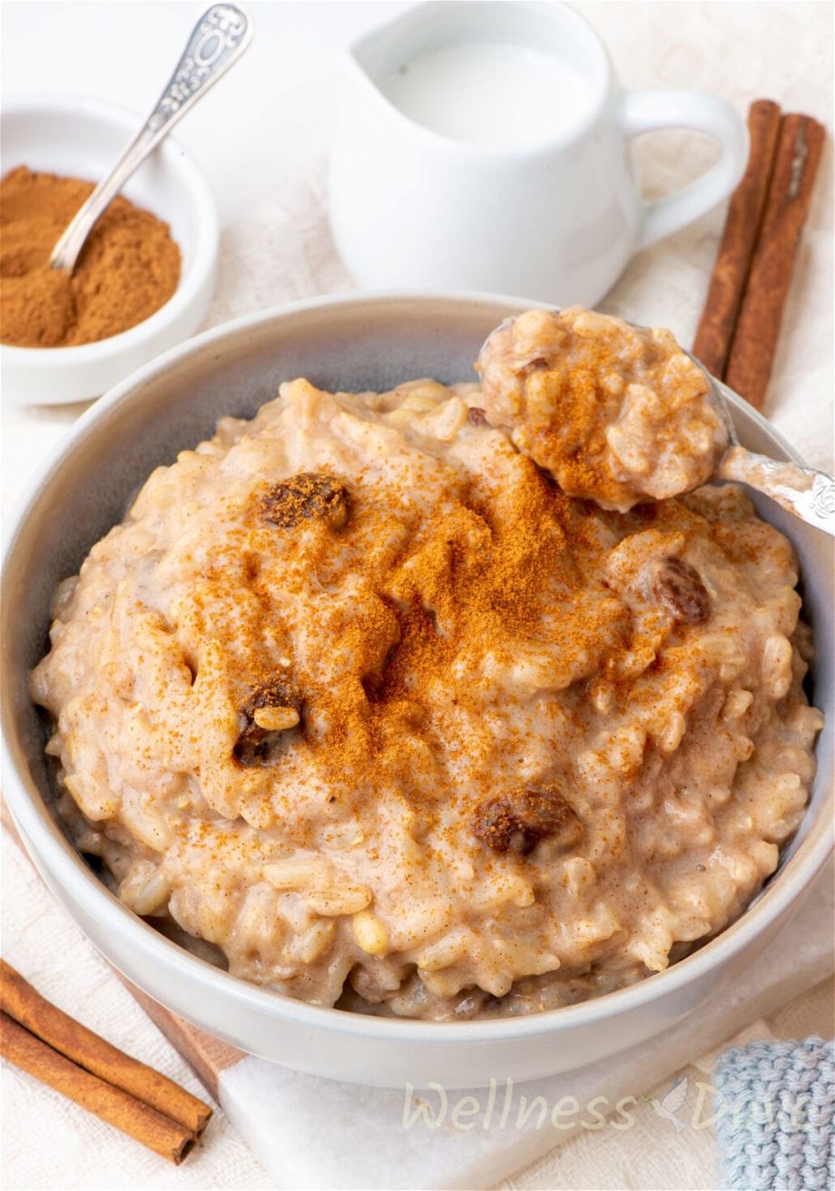 a close up, 3/4 angle view of the  quick vegan brown rice pudding in  a gray bowl