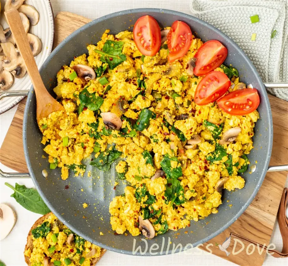 an over head view of the Vegan Tofu & Spinach Egg Scramble, some of the scramble is missing, presumably eaten