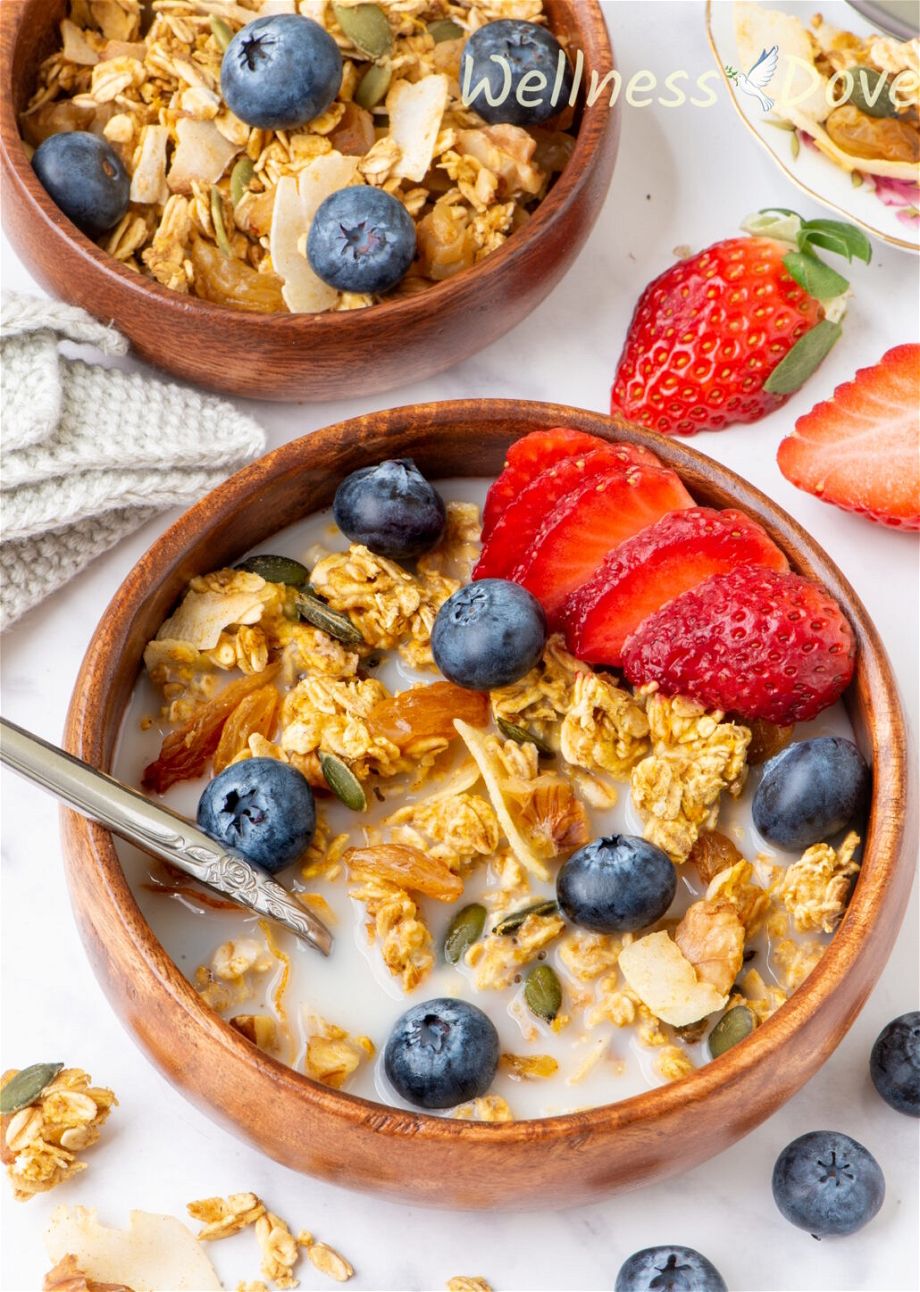 a macro shot of the homemade vegan sugar-free granola recipe in a wooden bowl with some plant based milk added to it