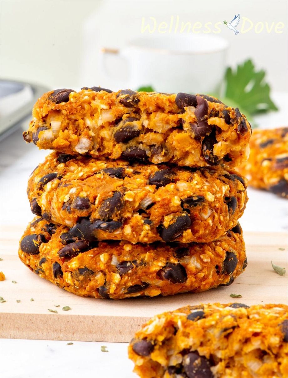 three of the Sweet Potato Black Bean Burgers stacked on top of each other, one of them is split in half.