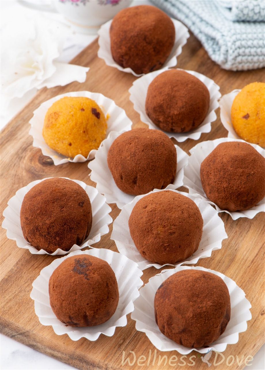 the vegan sweet potato vegan truffles in paper cups on top of a wooden board