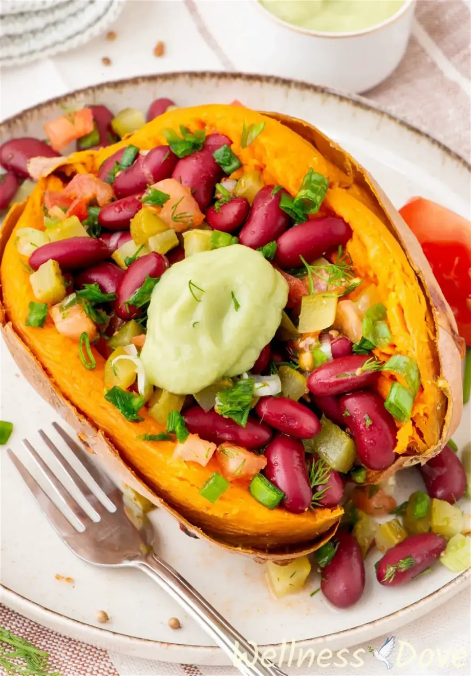 the bean stuffed vegan sweet potatoes in a plate, 3/4 angled shot