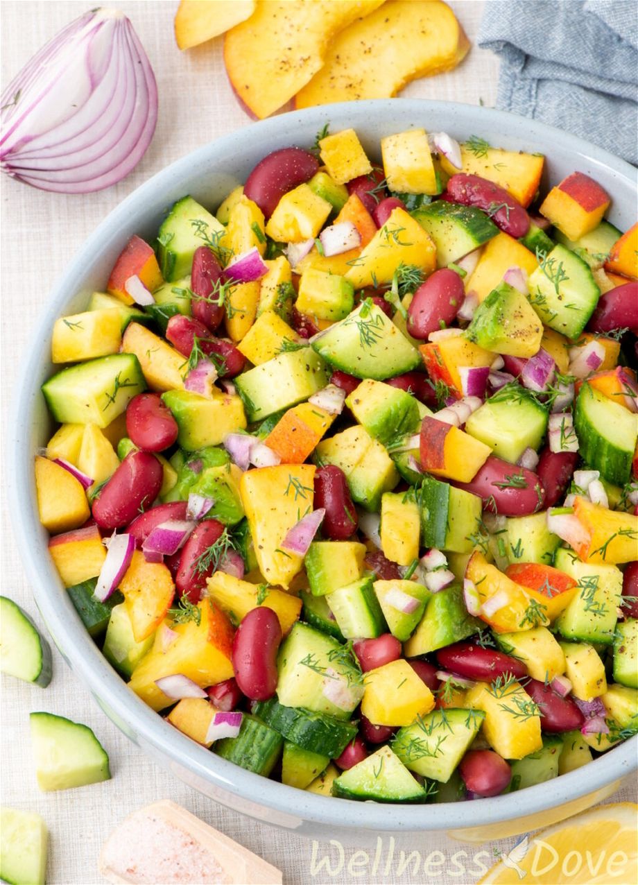 a macro shot of the vegan peach salad with beans in a blue bowl