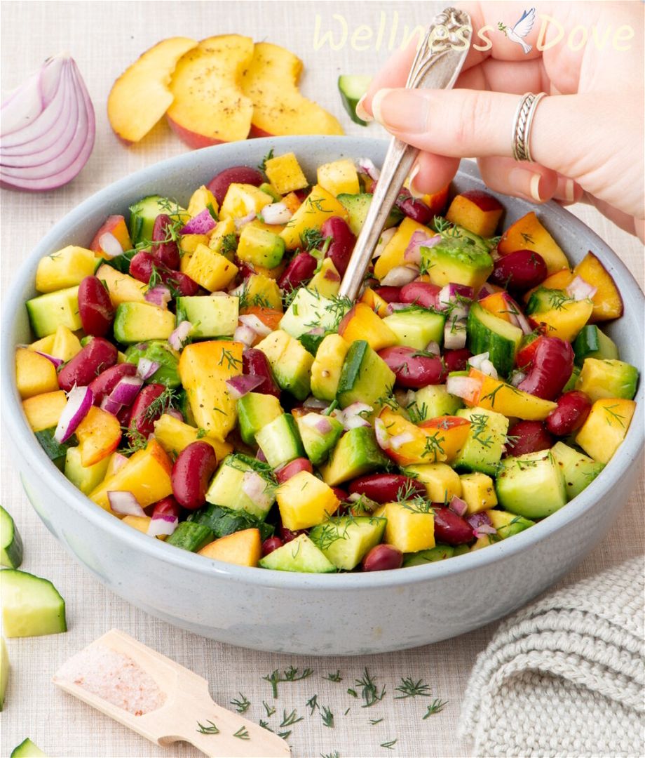 a 3/4 angled shot of the vegan peach salad with beans in a blue bowl