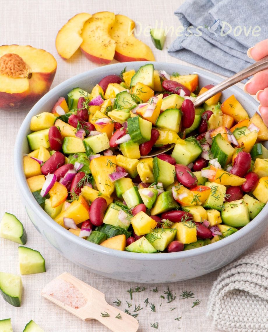 the vegan peach salad with beans in a smaller blue bowl, 3/4 angle view