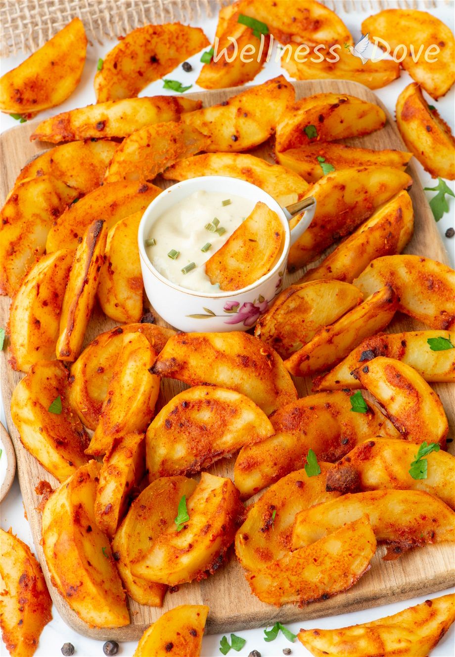 a 3/4 angled photo of the Baked Mustard Potato Vegan Wedges on a chopping board